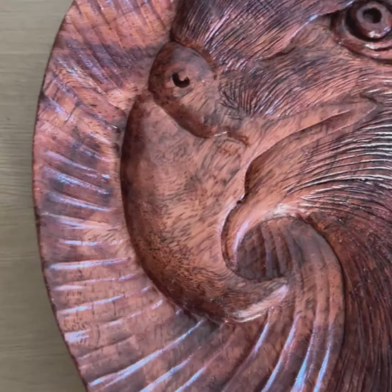Eagle tray: silent close-up of the round tray, showing its eagle-head motif and carved lines, then standing upright.