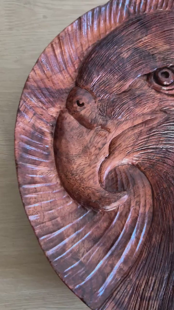 Eagle tray: silent close-up of the round tray, showing its eagle-head motif and carved lines, then standing upright.